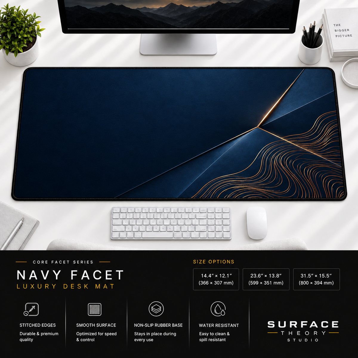 Navy Facet desk mat beneath a monitor on a bright desk with a white keyboard and mouse.