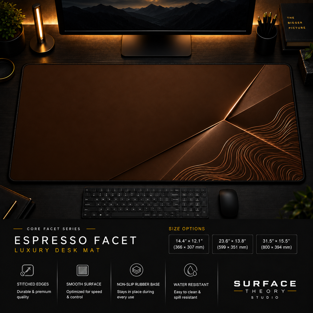 Espresso Facet desk mat in a dark workstation with warm monitor lighting.