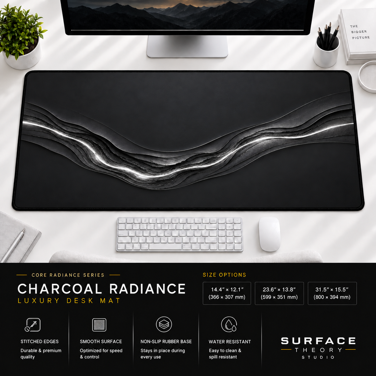 Charcoal Radiance desk mat beneath a monitor on a bright desk with a white keyboard and mouse.