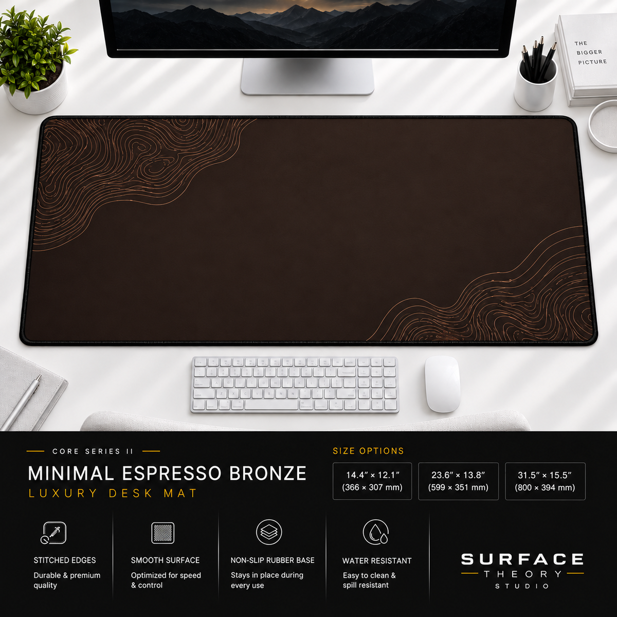 Minimal Espresso Bronze desk mat beneath a monitor on a bright desk with a white keyboard and mouse.