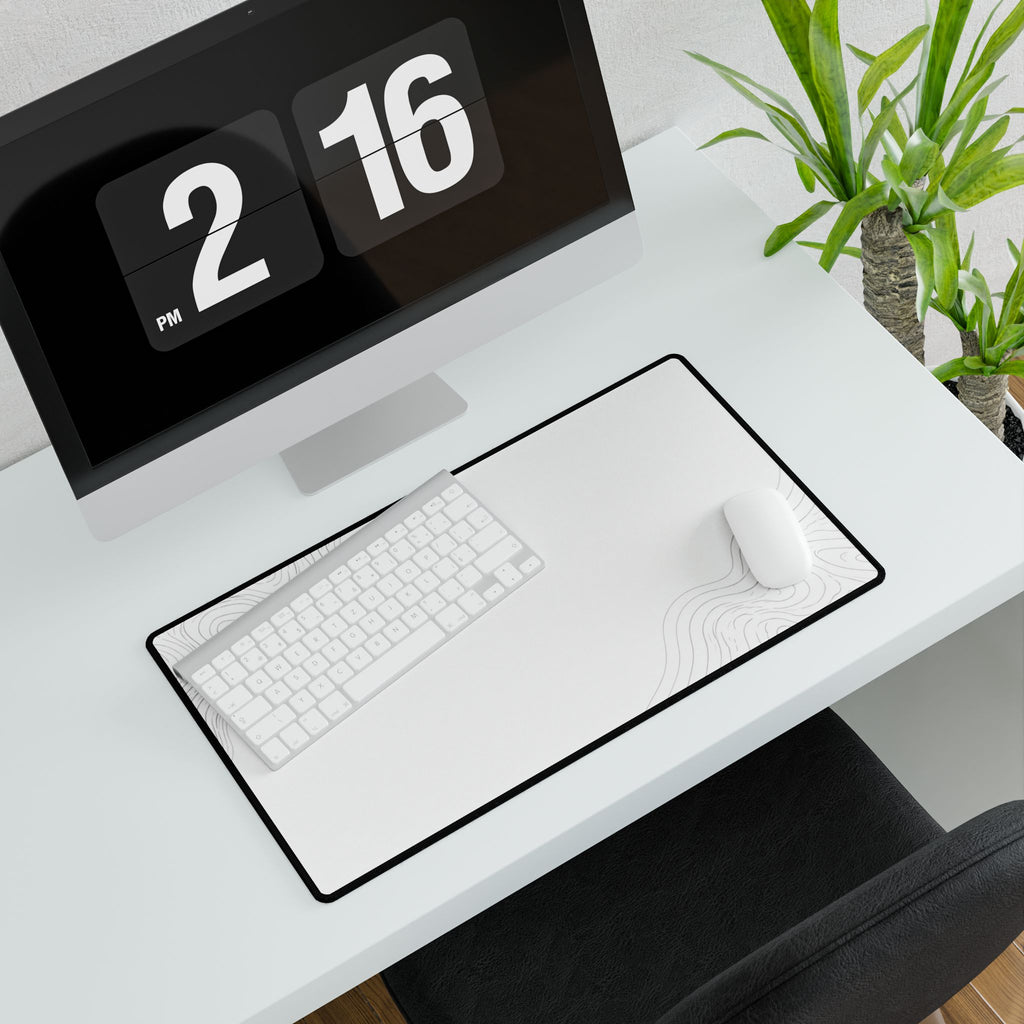 Minimal White medium-format desk mat beneath a white keyboard and mouse, viewed at an angle.
